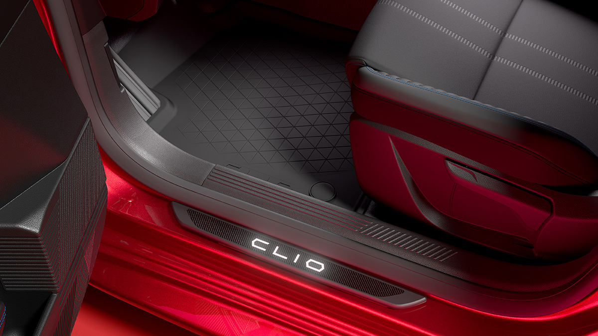 Detailaufnahme des Fußraums im Renault Clio mit moderner Fußmatte und beleuchtetem Clio-Logo.
