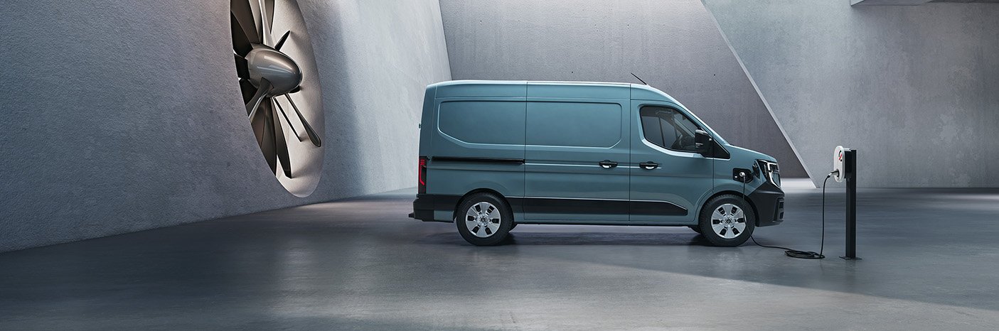 Ein blauer Transporter steht in einem modernen Raum mit einem großen Ventilator und eine Ladestation.