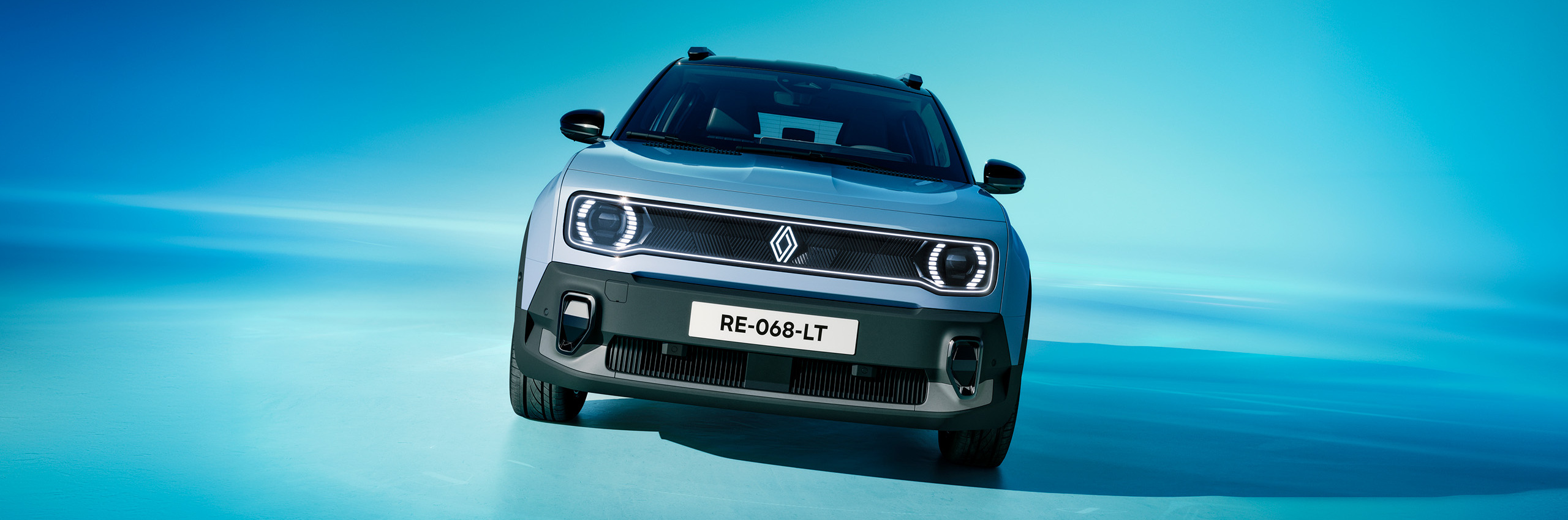 Frontansicht eines modernen Renault-Elektroautos vor blauem Hintergrund, mit Kennzeichen RE-068-LT.