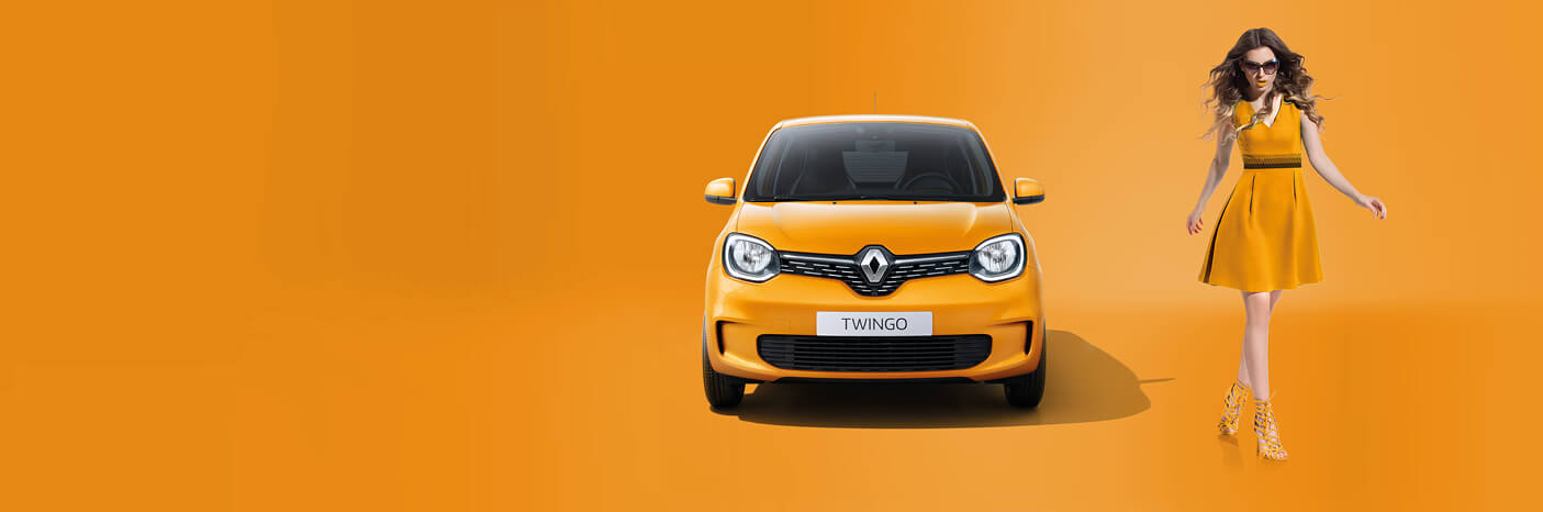 Ein strahlend gelber Renault Twingo steht vor orangefarbigem Hintergrund, während eine Modelfrau in einem gelben Kleid posiert.