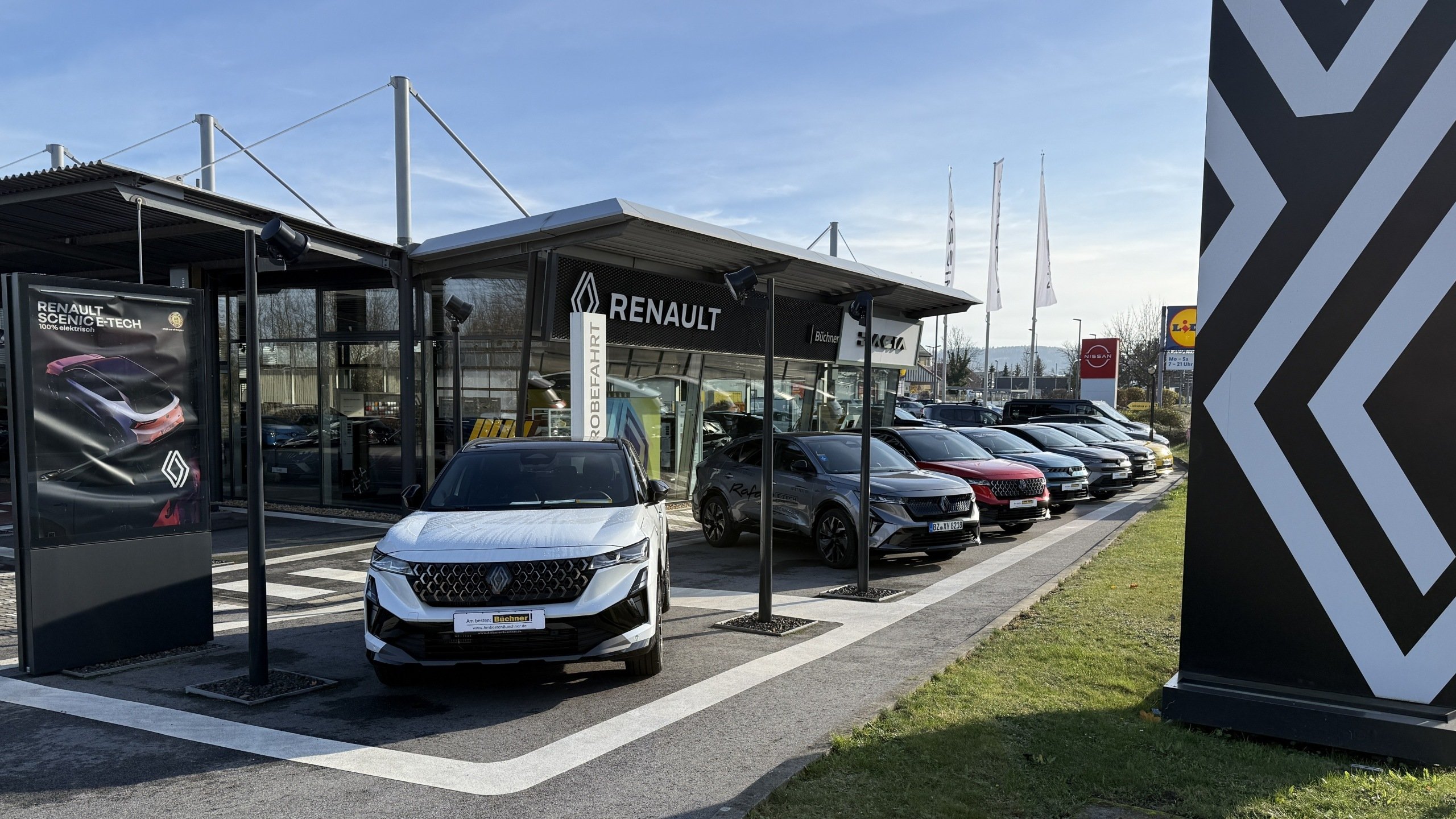 Renault Autohaus mit mehreren Fahrzeugen im Freien und der Aufschrift 'Renault' sichtbar.