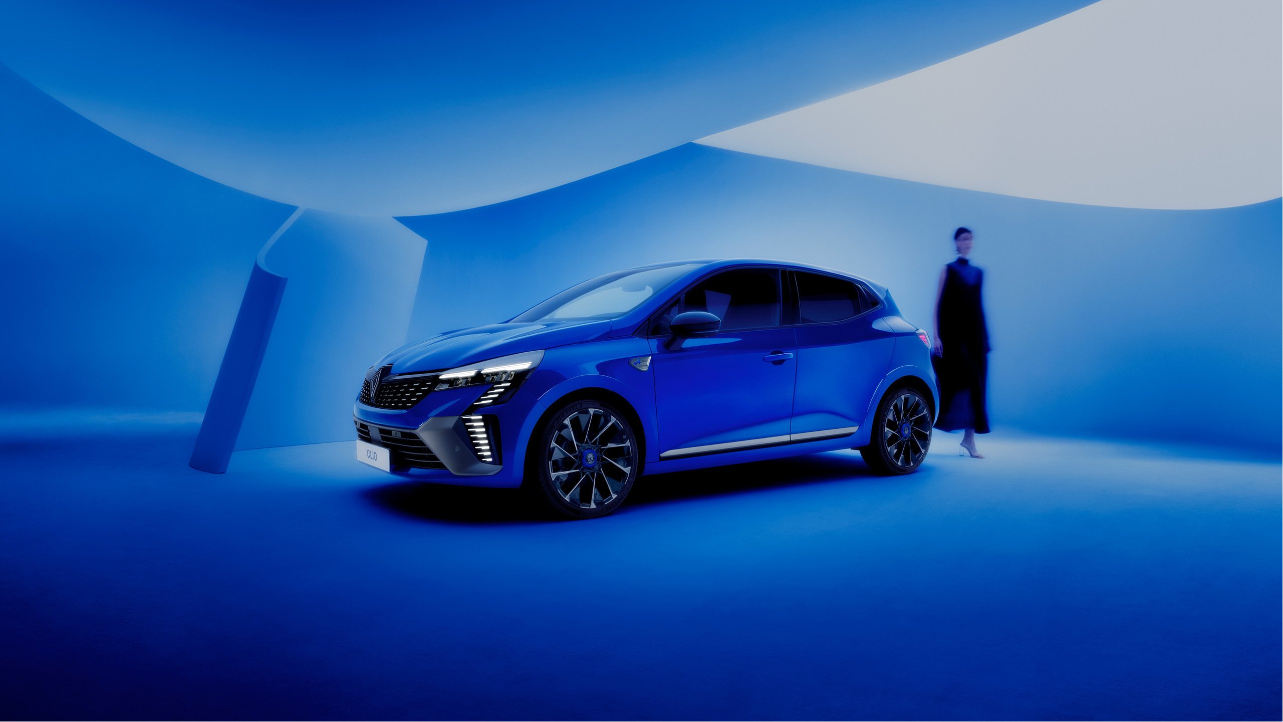 Blauer moderner Sportwagen in einem stilvollen blauen Raum, daneben eine Person in schwarzer Kleidung.