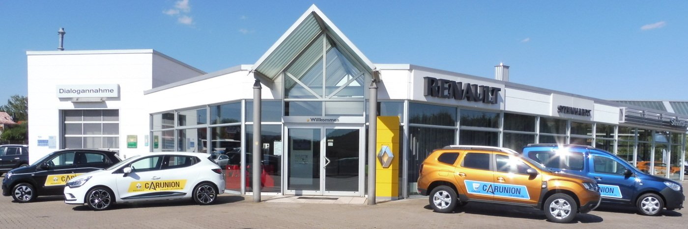 Renault Autohaus mit mehreren Fahrzeugen vor dem Gebäude, darunter ein orangefarbener SUV und mehrere Kleinwagen.