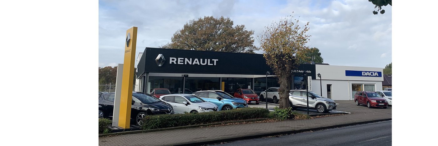 Renault und Dacia Autohaus mit verschiedenen Fahrzeugen auf dem Parkplatz, umgeben von Bäumen.