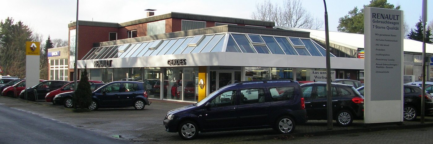 Renault Autohaus mit modernen Glasfronten und mehreren Fahrzeugen auf dem Parkplatz.