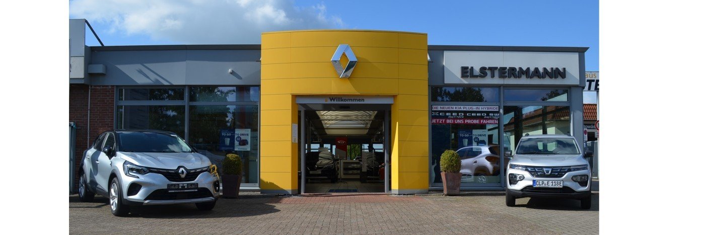 Renault Autohaus Elstermann mit zwei Autos vor dem Eingang. Gelbe Fassade im Hintergrund, blauem Himmel.