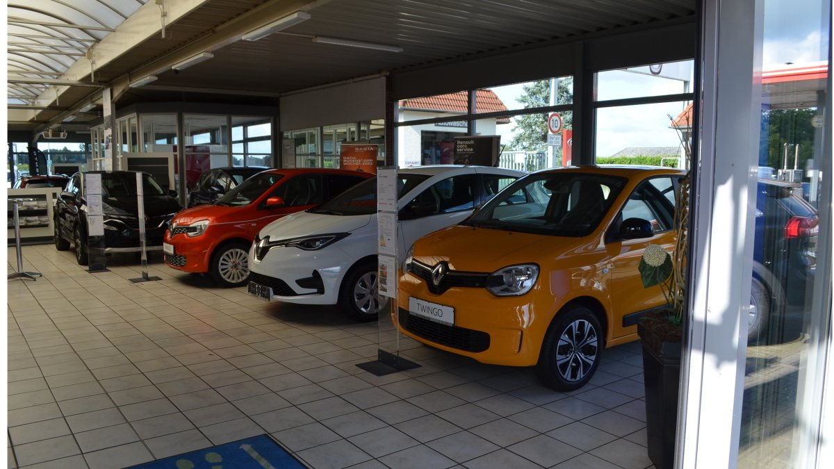 Autohaus mit verschiedenen Renault-Modellen in einem Ausstellungsraum. Fahrzeuge in verschiedenen Farben ausgestellt.