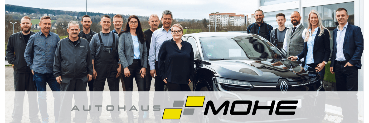 Mitarbeiter des Autohauses Mohe stehen vor einem schwarzen Renault, Gruppenfoto im Freien.