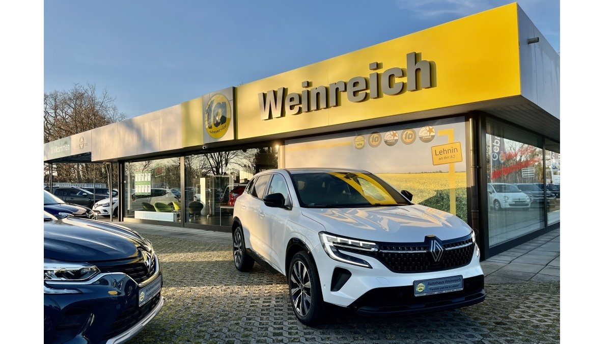 Renault SUV vor dem Autohaus Weinreich mit gelbem Schild und modernen Fahrzeugen im Hintergrund.