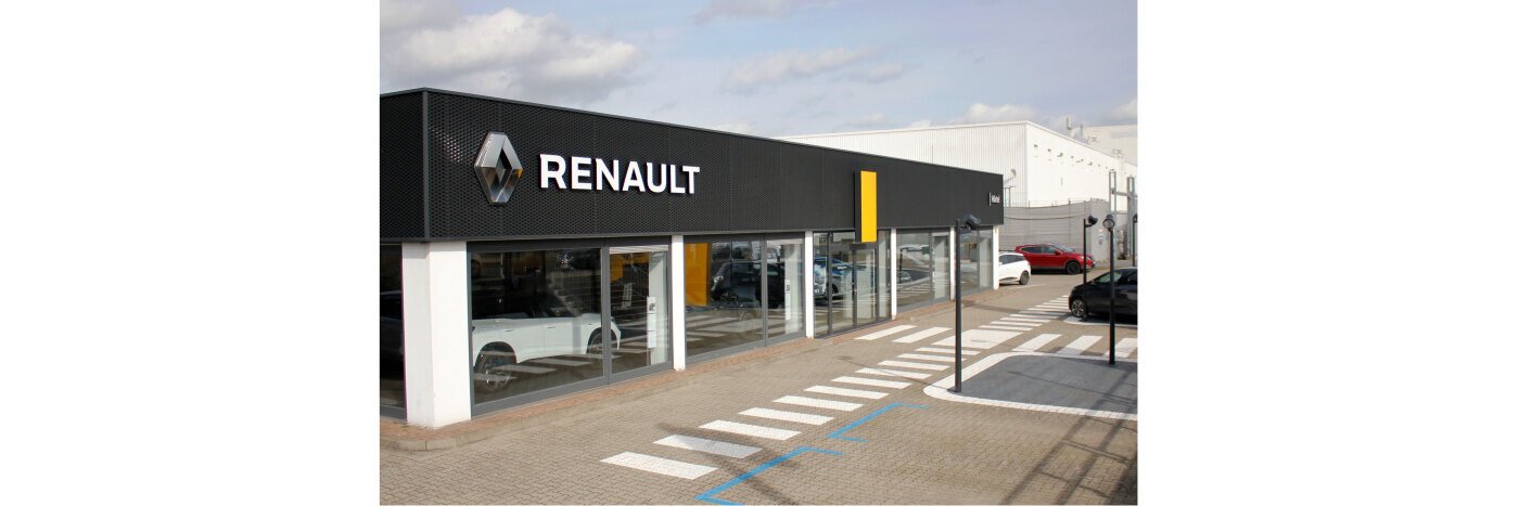 Renault Autohaus mit moderner Fassade und ausgestellten Fahrzeugen, asphaltiertes Verkaufsgebiet.