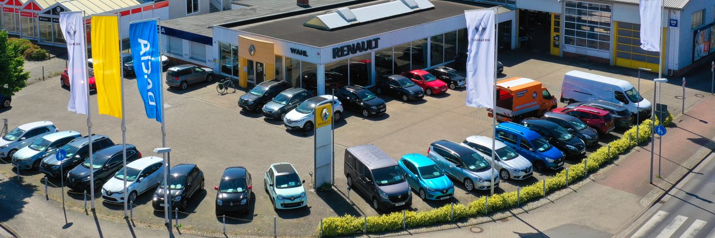 Renault Autohaus mit einer Vielzahl von Autos auf dem Parkplatz, einschließlich SUV und Nutzfahrzeugen.