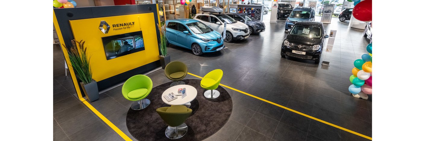 Renault Autohaus mit mehreren Fahrzeugen, einem Empfangsbereich und bunten Dekorationen.