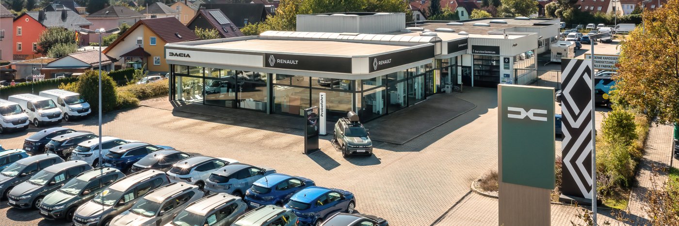 Renault und Dacia Händler mit gesellten Autos auf dem Parkplatz in einer Stadtlandschaft.