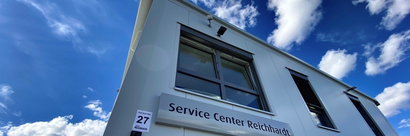 Ansicht des Service Centers Reichhardt unter blauem Himmel mit Wolken.