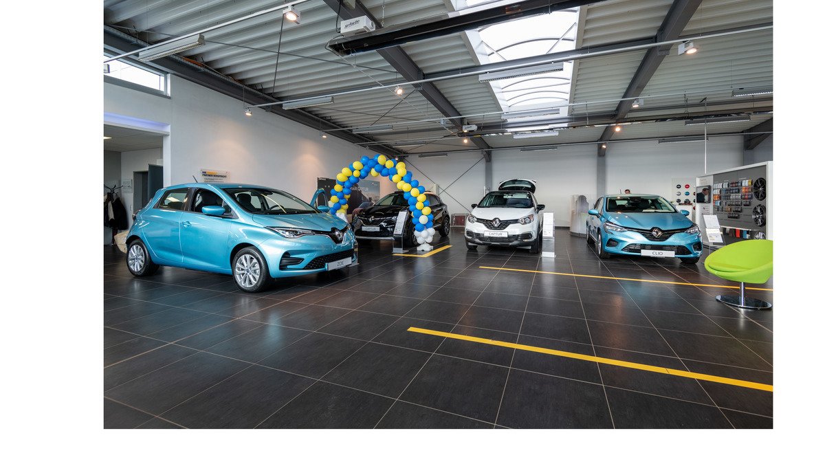 Renault Autohaus mit mehreren Fahrzeugen, darunter ein blauer und weiße Modelle, sowie einer Ballonunterstützung im Hintergrund.
