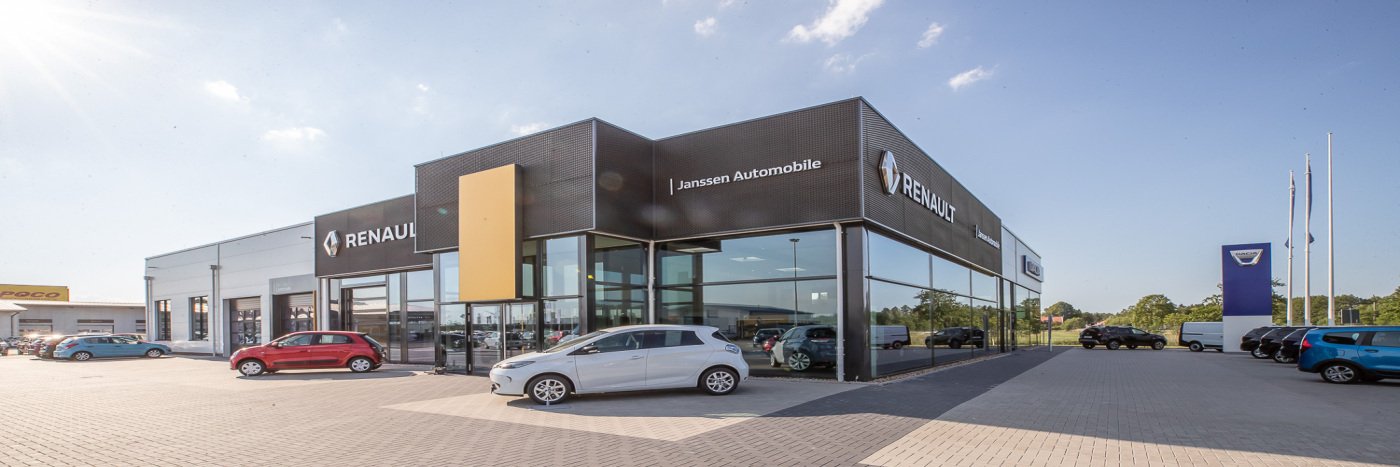 Renault Autohaus Janssen Automobile mit mehreren Autos auf dem Parkplatz, bei sonnigem Wetter.