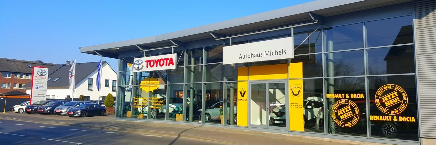Autohaus Michels mit Schildern von Toyota, Renault und Dacia in hellen Lichtverhältnissen.