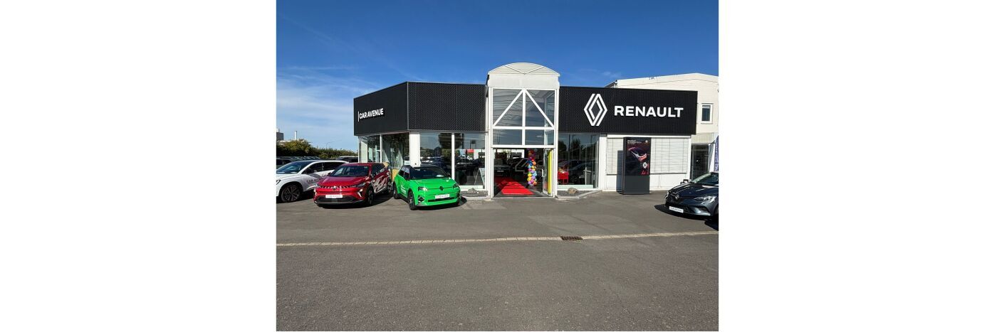 Renault-Autohaus mit mehreren Autos, darunter ein grünes und rotes Fahrzeug, an einem sonnigen Tag.