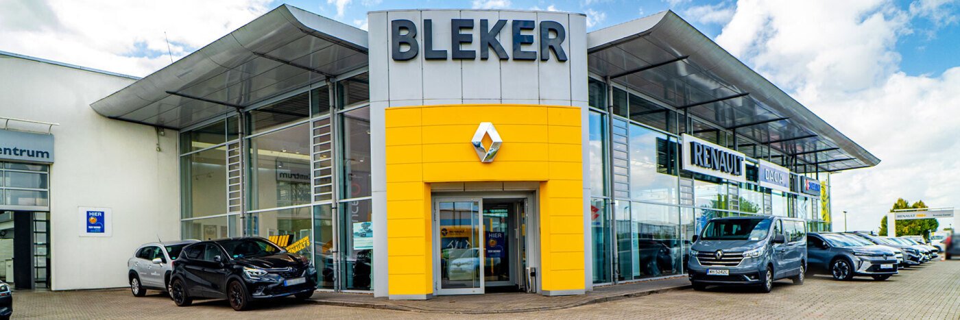 Renault Autohaus Bleker mit gelbem Eingangsbereich und mehreren Fahrzeugen auf dem Parkplatz.