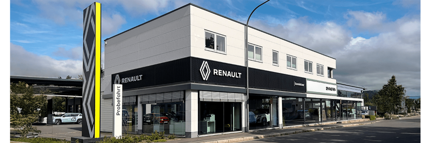 Renault Autohaus mit modernem Design, vorgelagerten Fahrzeugen und markantem Logo an der Fassade.