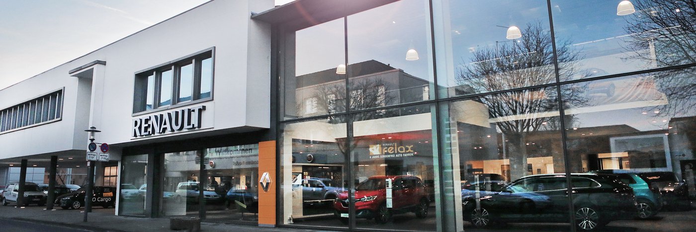 Renault Autohaus mit großen Fenstern, Innenraum sichtbar, mehrere Autos in der Ausstellung.