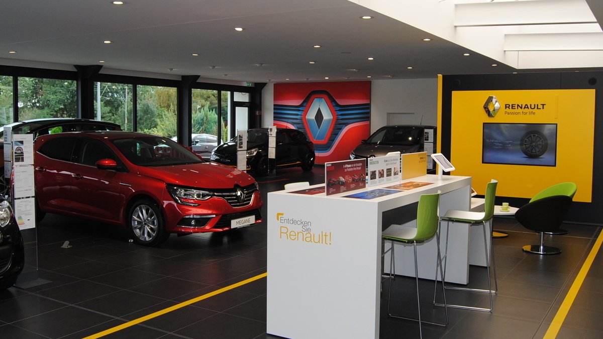 Renault Autohaus mit roten Autos, Informationsständen und modernem Design im Showroom.
