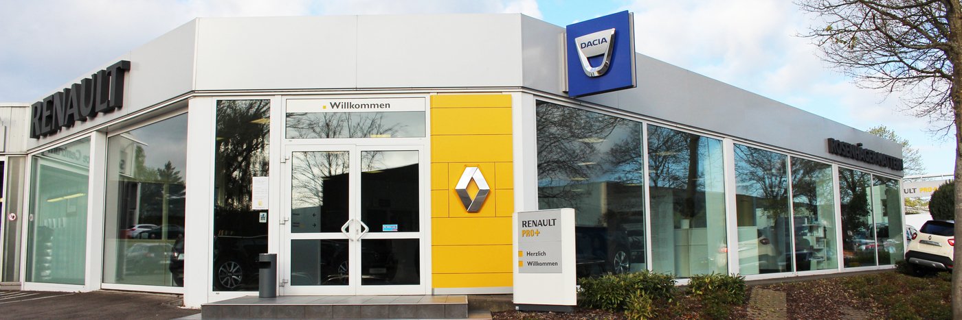 Renault und Dacia Autohaus mit modernen Glasfronten und gelbem Schild. Willkommenstafel an der Eingangstür.