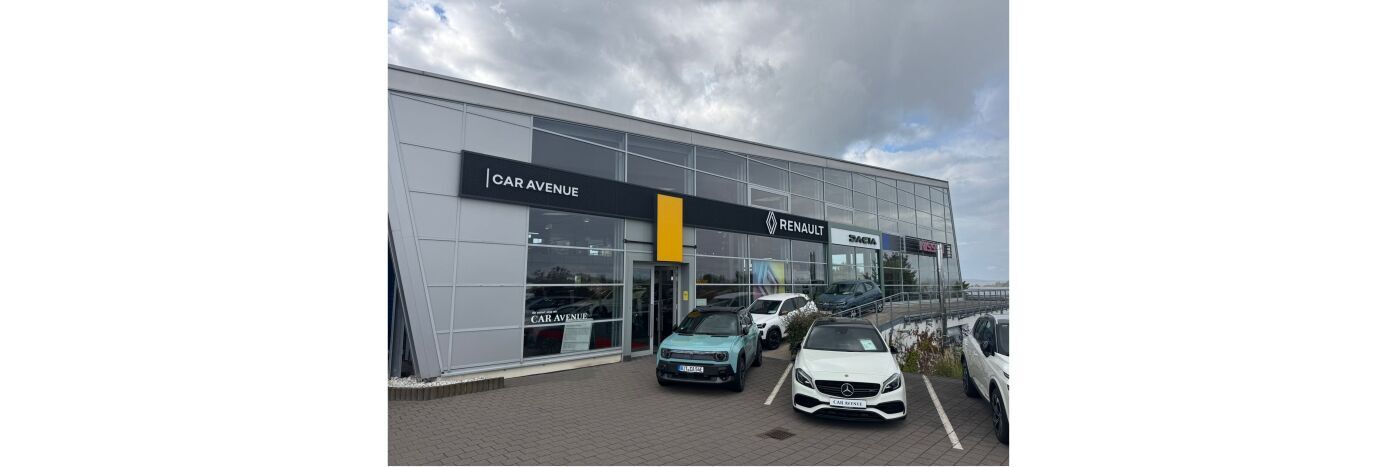 Fassade des Autohauses Car Avenue mit Renault-Logos und mehreren Autos auf dem Parkplatz.