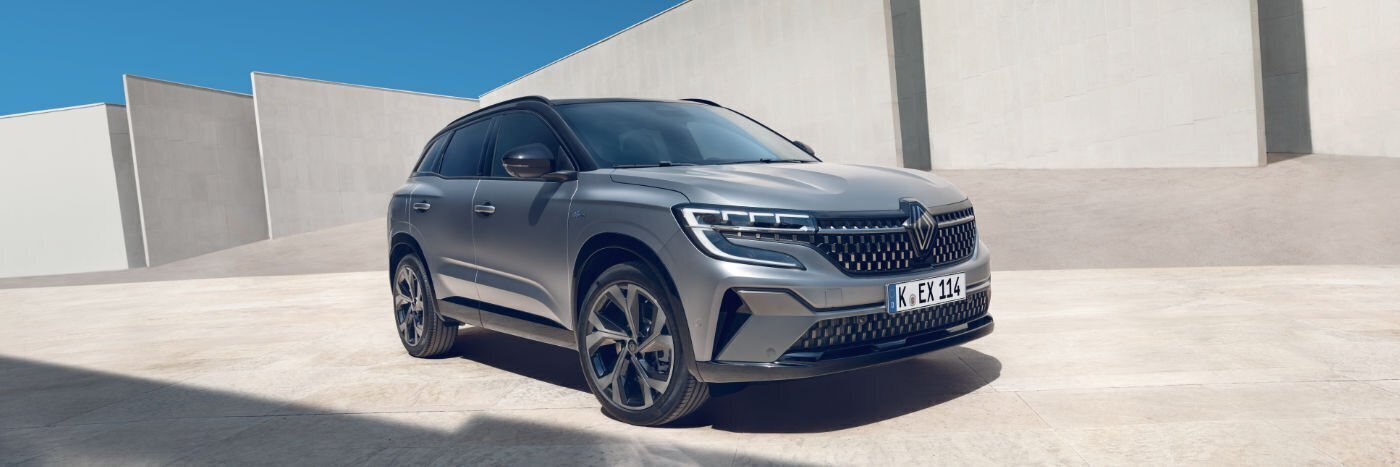 Renault SUV in modern Architektur, grau lackiert, vor klar blauem Himmel geparkt.