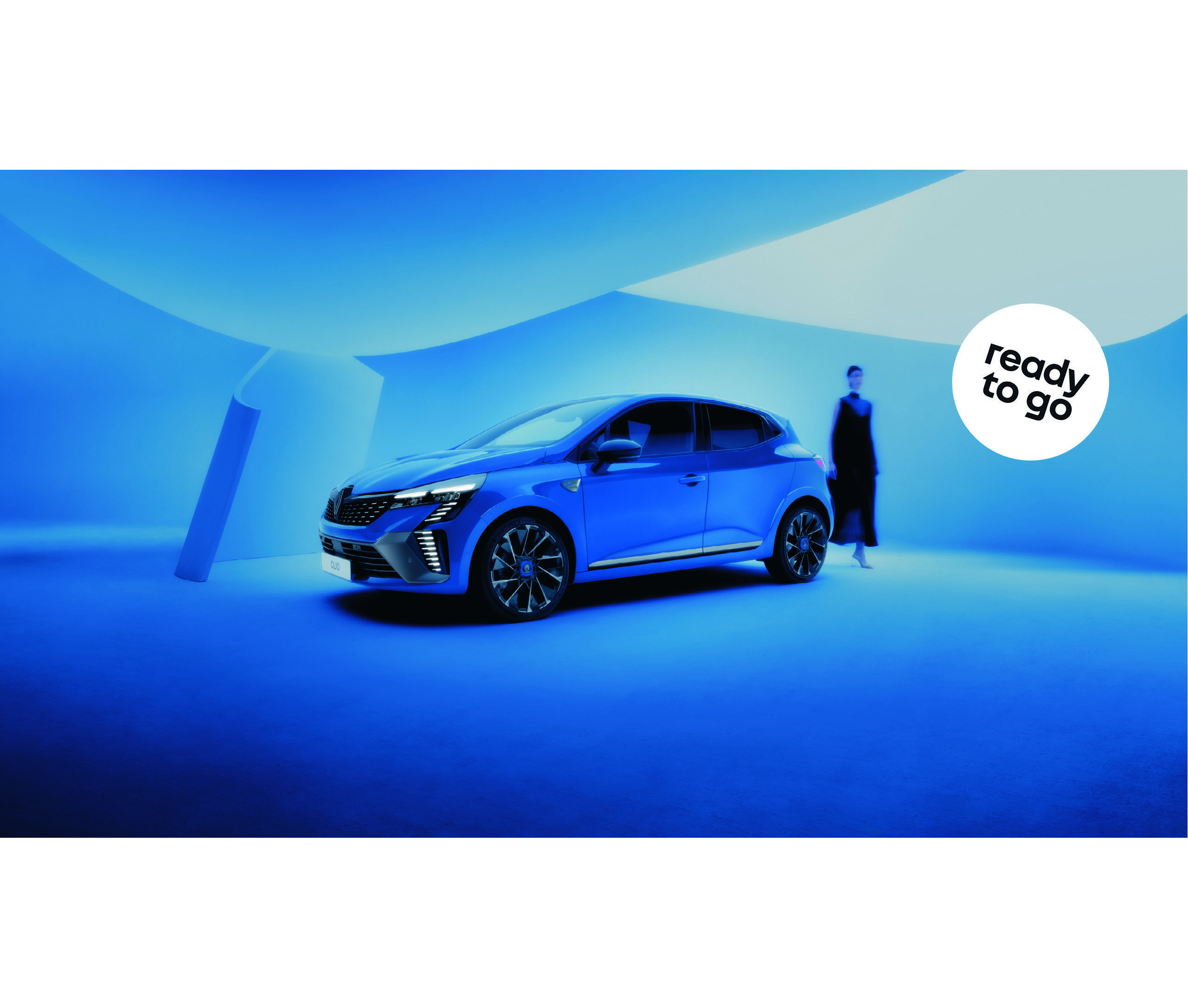 Ein blauer Wagen wird in einem blauen Raum präsentiert, mit einer Person im Hintergrund. Text: bereit zu fahren.