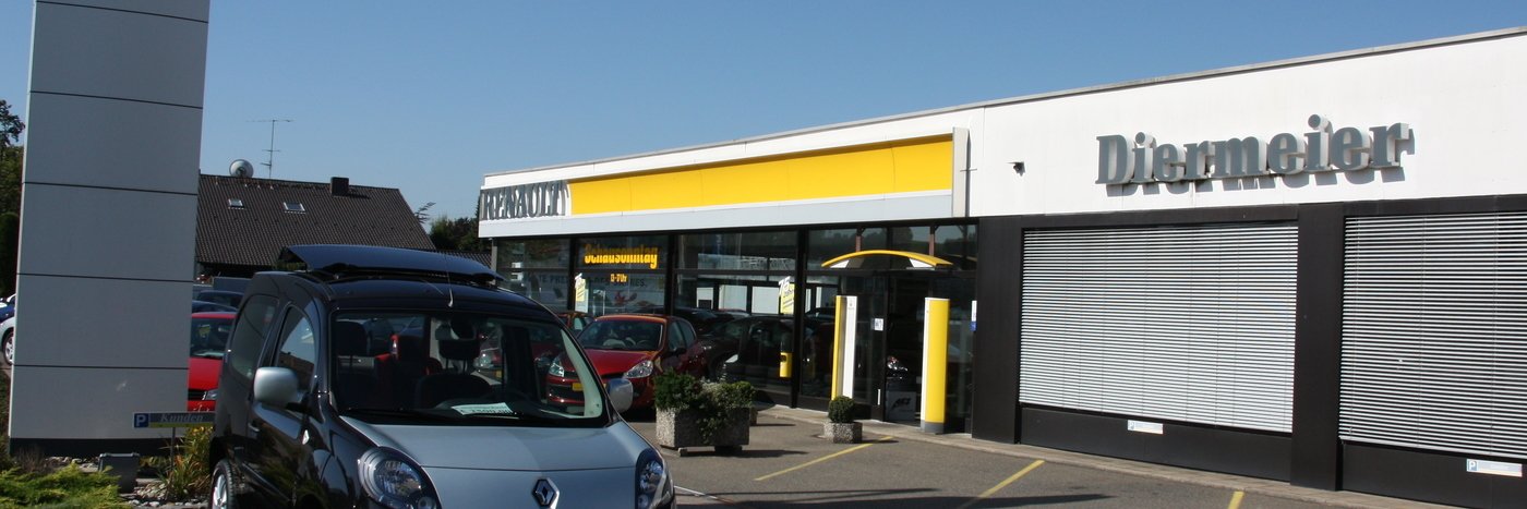Autohaus Diermeier mit verschiedenen Fahrzeugen und einem modernen Gebäude. Im Vordergrund ein grauer Renault.