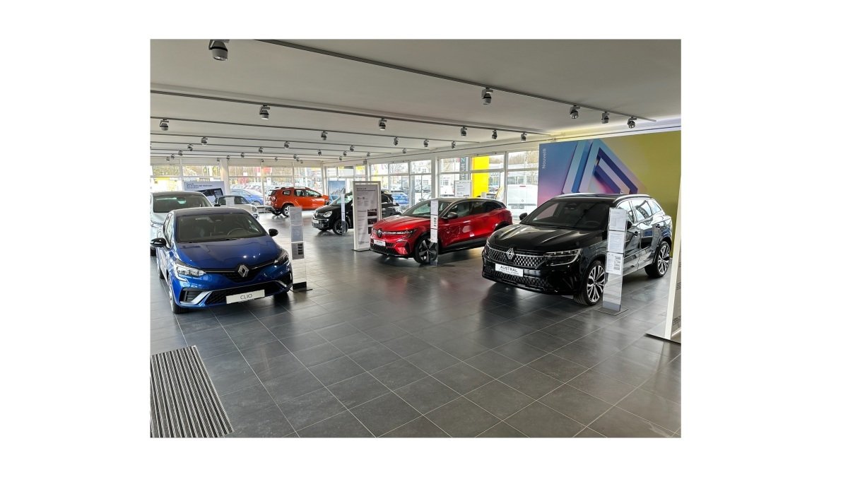 Renault-Autohändler, vier Autos in einem modernen Ausstellungsraum, beleuchtet und ordentlich angeordnet.