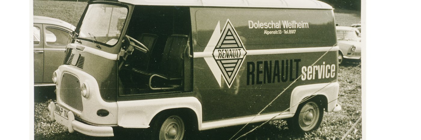 Ein alter Renault Service Transporter auf einem Parkplatz, umgeben von weiteren Fahrzeugen.