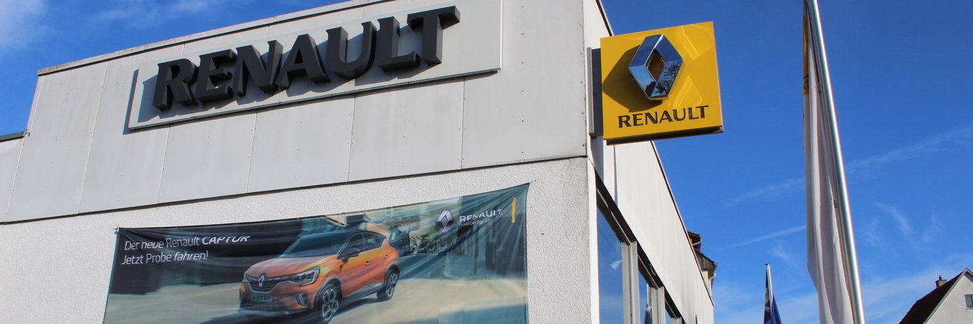 Renault Händlergebäude mit Logo und Banner, der neuen Renault Modelle bewirbt.