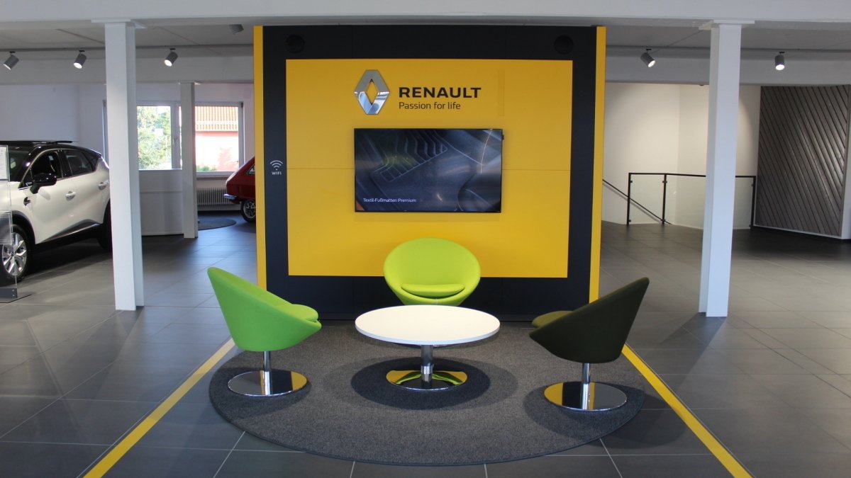 Moderne Renault-Autohäuser mit Sitzbereichen, TV-Bildschirm und stilvollem Design.