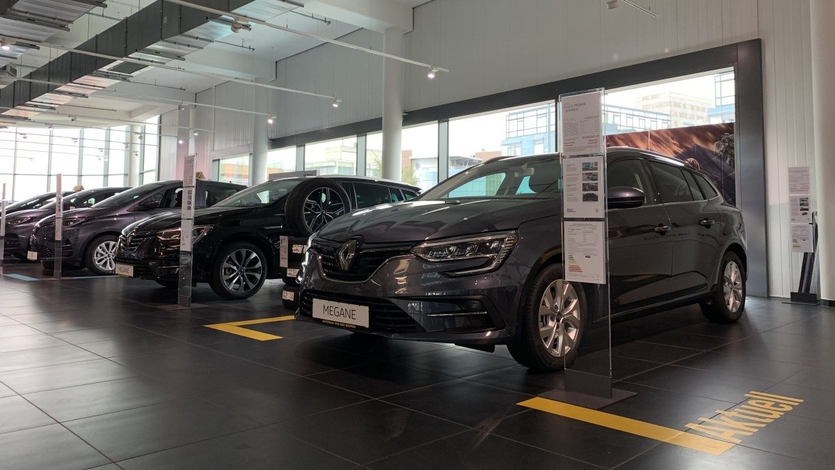 Renault Megane in einem modernen Autohaus, umgeben von weiteren Fahrzeugen, gut beleuchtet.
