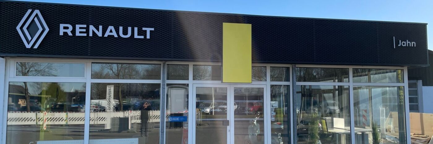Die Fassade eines Renault Autohauses mit Logo und gelbem Schild in der Nähe von John.