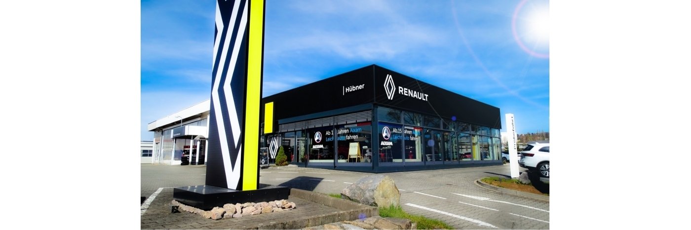 Renault Autohaus mit moderner Fassade, deutlich erkennbaren Logo und klaren Himmel im Hintergrund.