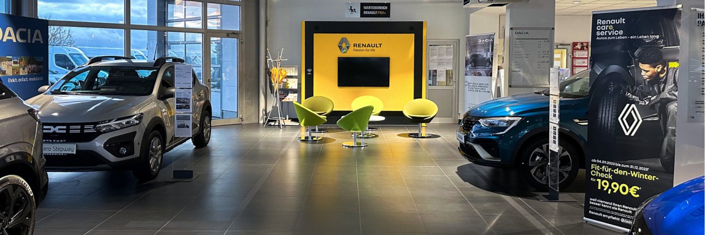 Renault Autohaus mit mehreren Fahrzeugmodellen, Sitzbereich und Werbung für Renault Service in modernen Räumlichkeiten.